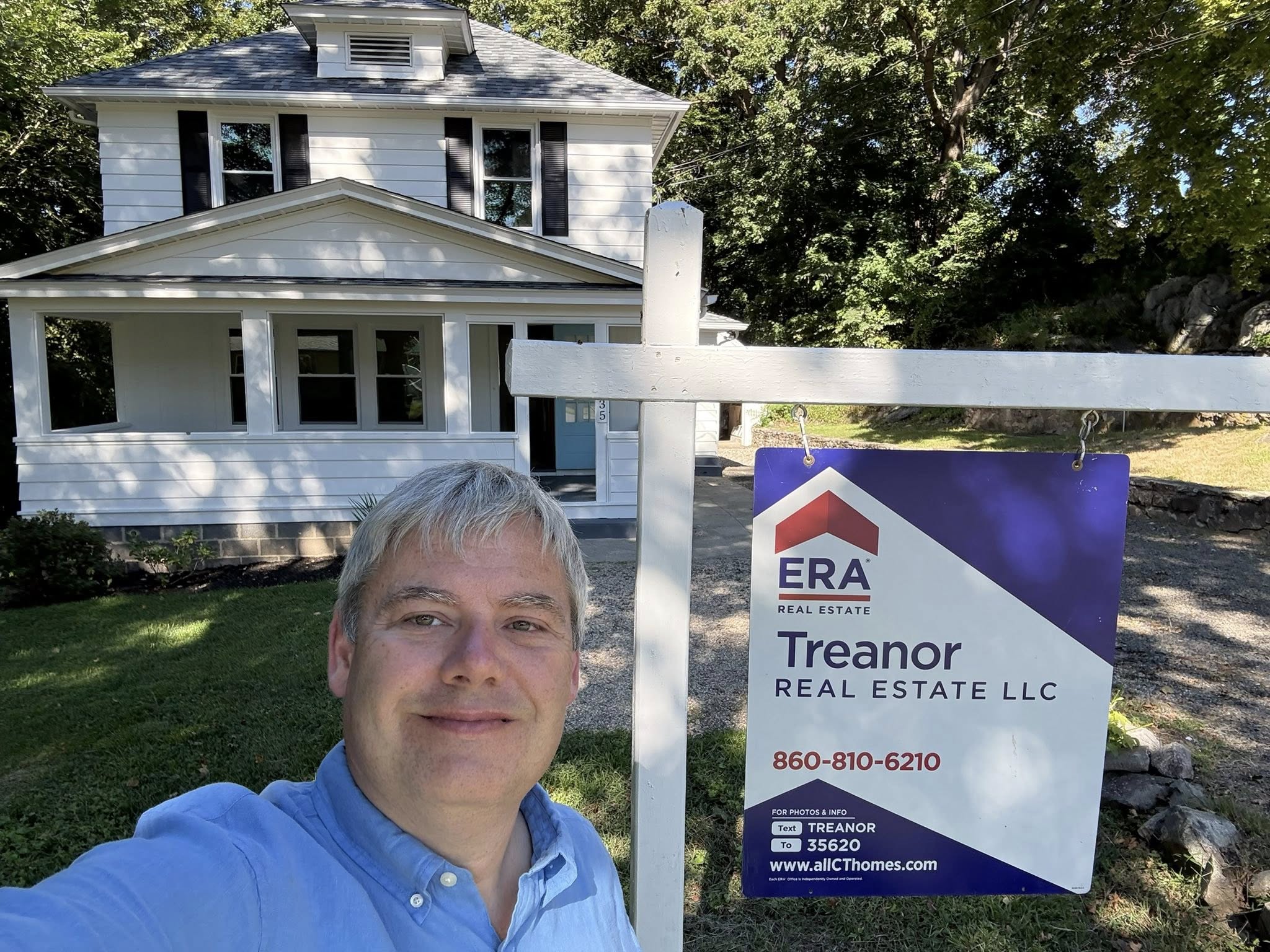 Real estate agent in front of a Litchfield home helping a Litchfield first time homebuyer.
